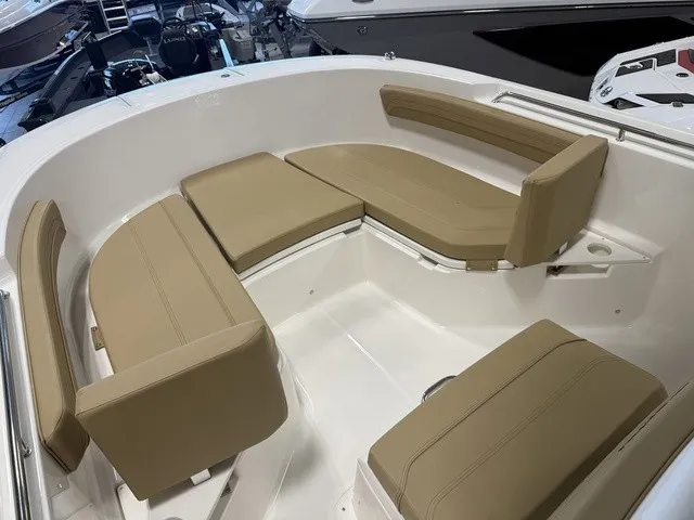 Slide: The Image of The image shows the bow area of a Trophy T24CC boat with beige cushioned seating. - 24