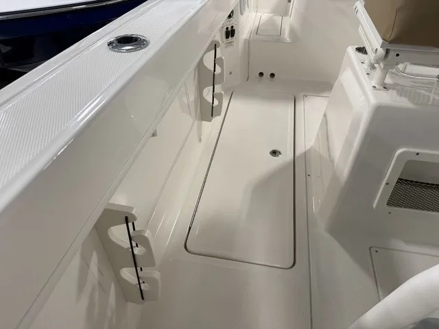 Slide: The Image of The image shows the deck of a 2025 Trophy T24CC boat with white surfaces and cup holders. - 34