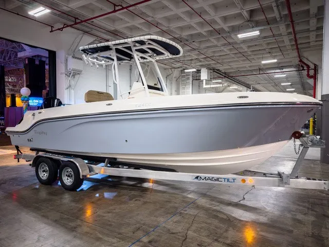 Slide: The Image of A 2025 Trophy T24CC boat is on a trailer in a warehouse. - 2