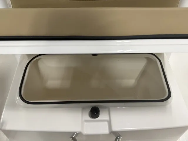 Slide: The Image of An open storage compartment on a boat with a white frame and beige cover. - 26