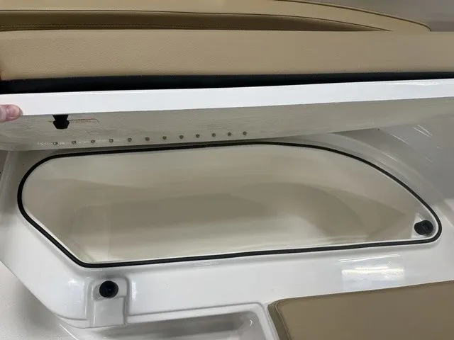 Slide: The Image of An open storage compartment on a 2025 Trophy T24CC boat, featuring beige upholstery. - 28