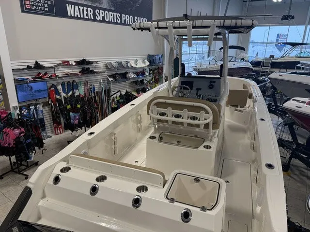 Slide: The Image of The image shows a 2025 Trophy T24CC boat in a showroom. It features a center console and is surrounded by watersports gear. - 6