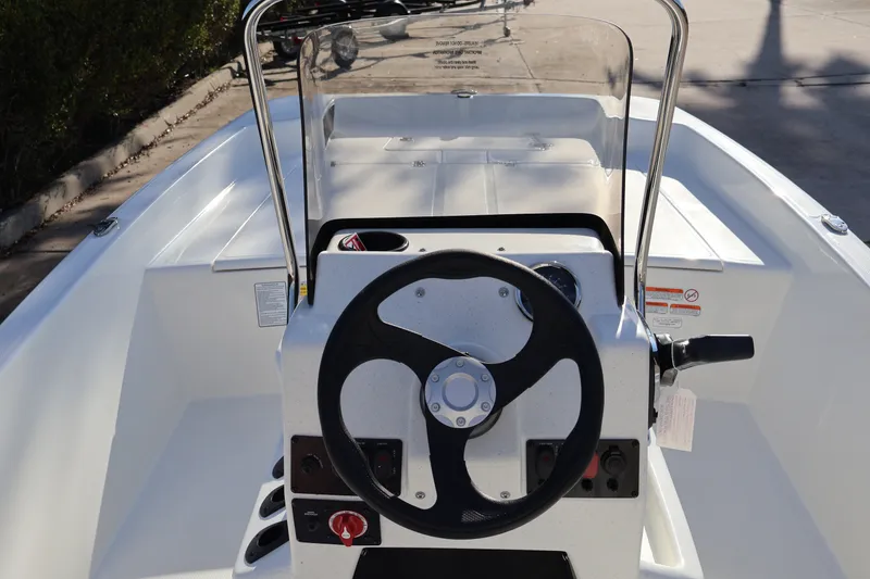 Slide: The Image of 2027 Mako Pro Skiff 17 CC boat console with steering wheel and controls. - 8