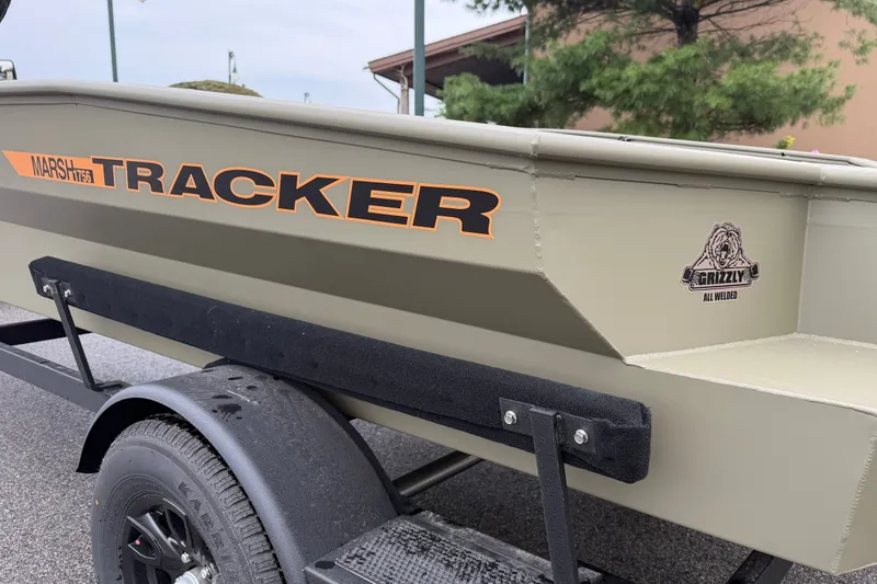 Slide: The Image of 2027 Tracker Grizzly 1756 T Marsh boat on trailer, showcasing logo and design. - 68