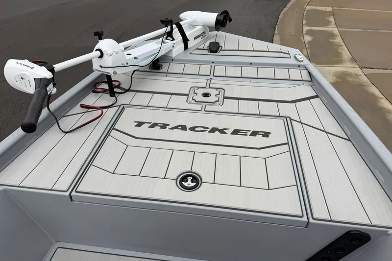 Slide: The Image of 2027 Tracker Bass Tracker Classic CC boat deck with trolling motor, parked on pavement. - 13