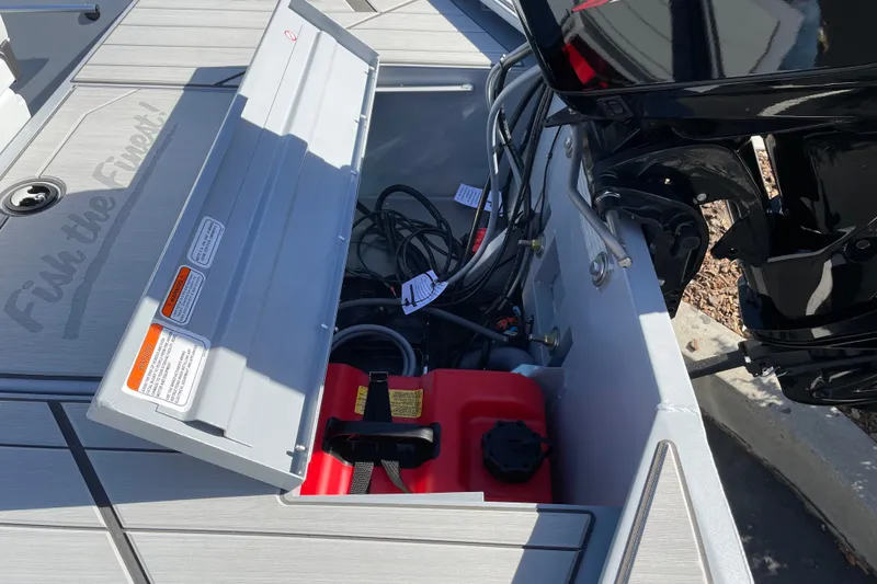Slide: The Image of Open storage compartment on 2027 Tracker Bass Tracker Classic CC boat, showing engine and fuel tank. - 14