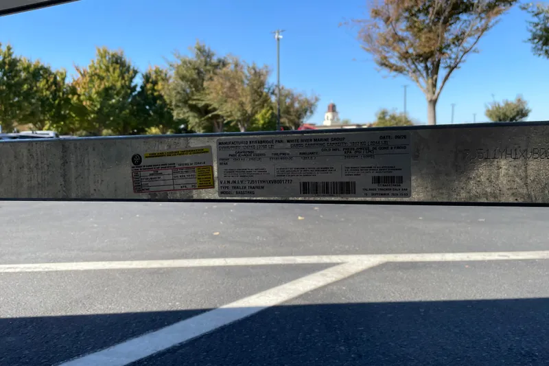 Slide: The Image of 2027 Tracker Bass Tracker Classic CC trailer label in parking lot with trees in background. - 68
