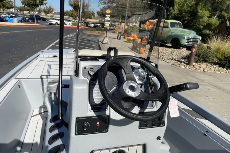 Slide: The Image of 2027 Tracker Bass Tracker Classic CC boat dashboard with steering wheel and controls. - 19