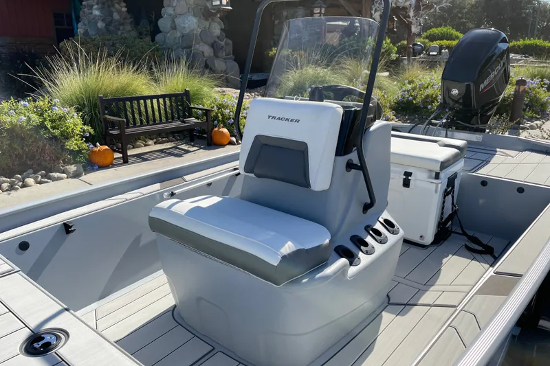 Slide: The Image of 2027 Tracker Bass Tracker Classic CC boat interior with seating and console, outdoors. - 17