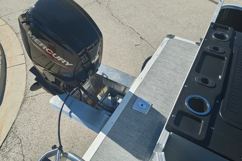 Slide: The Image of 2027 Sun Tracker Fishin' Barge 20 DLX with Mercury outboard motor, docked on pavement. - 46