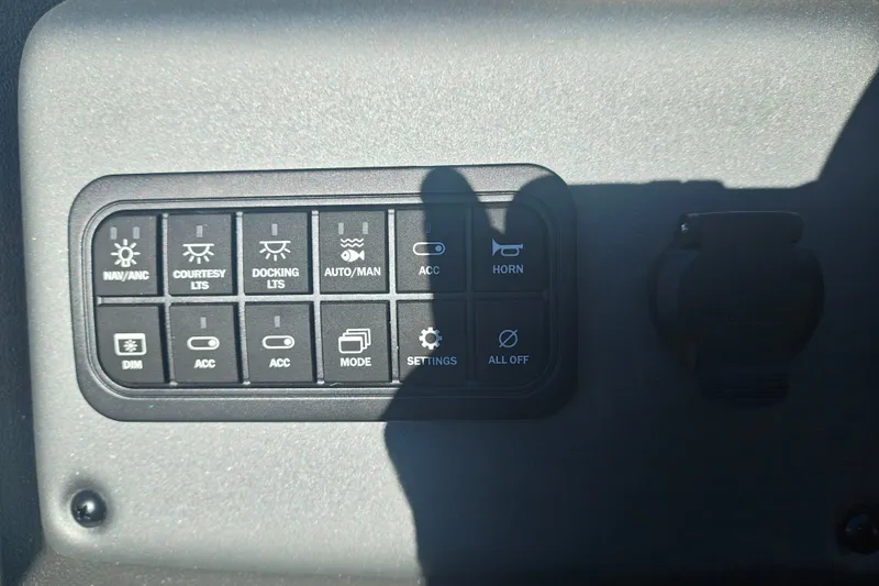 Slide: The Image of Control panel of 2027 Sun Tracker Fishin' Barge 20 DLX with various switches and buttons. - 29