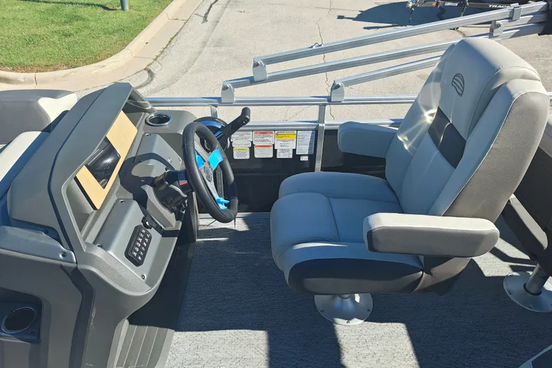 Slide: The Image of Interior view of a 2027 Sun Tracker Fishin' Barge 20 DLX, featuring a steering console and captain's chair. - 27