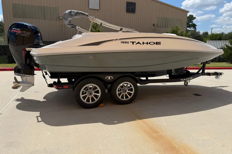 The Image of 2027 Tahoe 1950 boat on trailer with Mercury Pro XS engine, parked outdoors. - 0