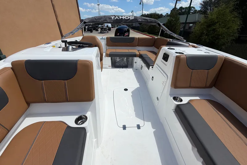 Slide: The Image of 2027 Tahoe 1950 boat interior with brown and black seating, cup holders, and steering console. - 10