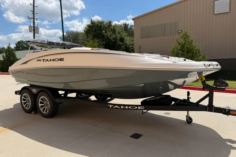 Slide: The Image of 2027 Tahoe 1950 boat on trailer, parked outdoors under a clear blue sky. - 3