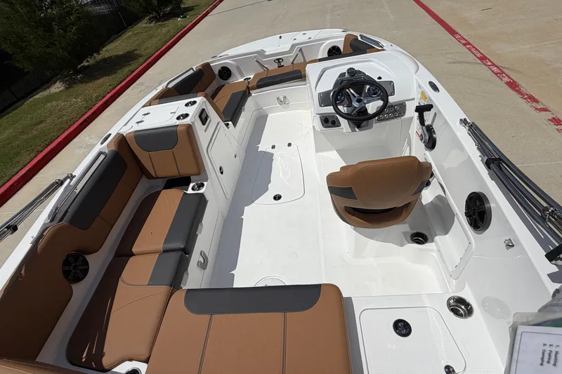 Slide: The Image of 2027 Tahoe 1950 boat interior with brown seating and modern steering console. - 7