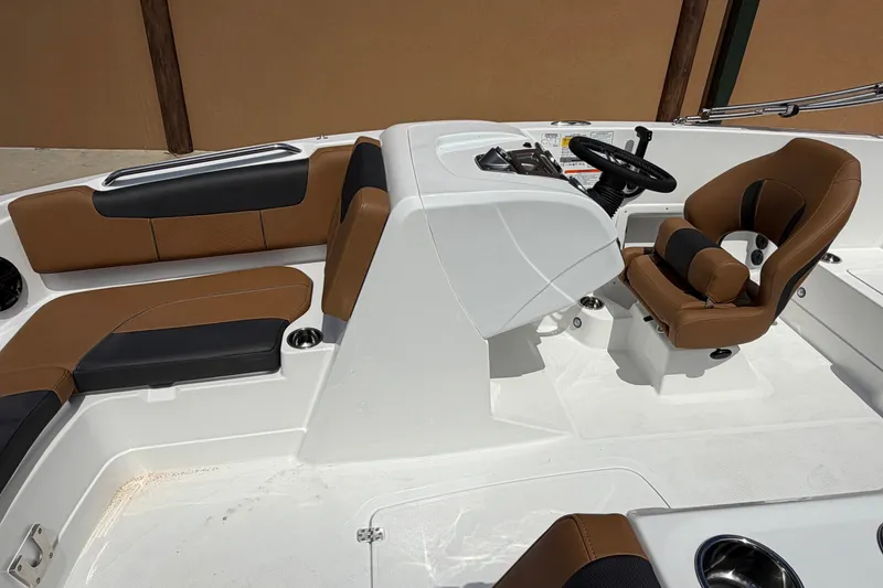 Slide: The Image of 2027 Tahoe 1950 boat interior with brown and black seating, steering wheel, and console. - 9