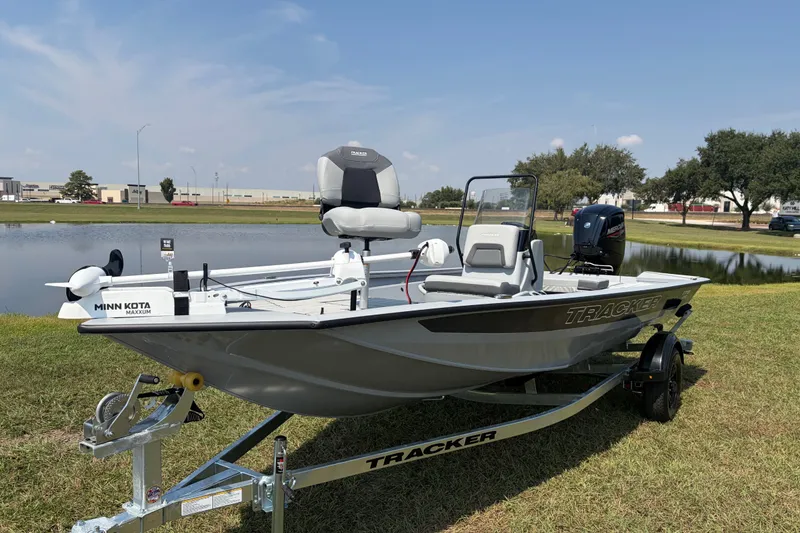Slide: The Image of 2027 Tracker Bass Tracker 175 CC boat on trailer by a pond, featuring Minn Kota motor. - 34