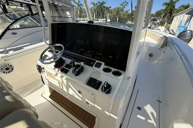 Slide: The Image of 2024 Cobia 350 Center Console boat cockpit with steering wheel and control panel. - 22