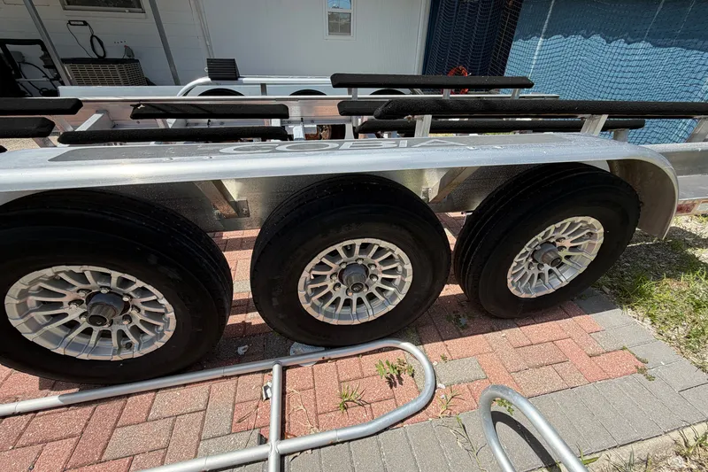 Slide: The Image of Triple-axle trailer for 2024 Cobia 350 Center Console boat on brick pavement. - 56