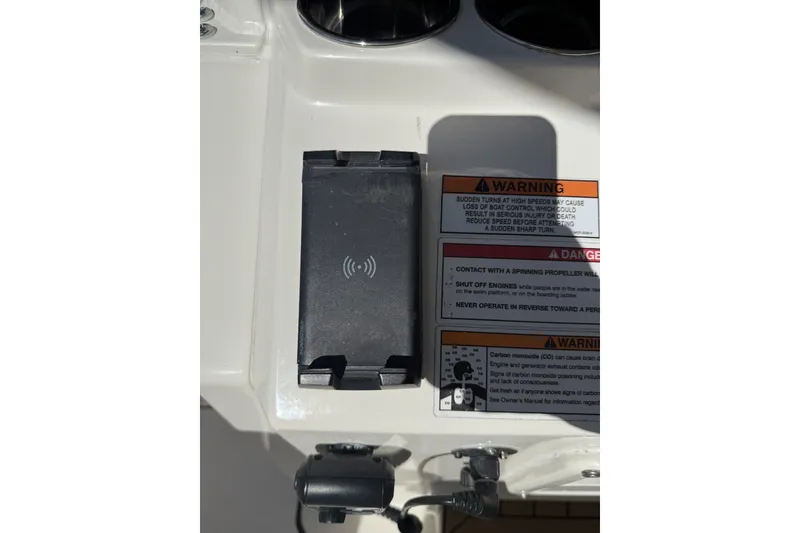 Slide: The Image of 2024 Cobia 350 Center Console dashboard with wireless charging pad and safety warnings. - 31