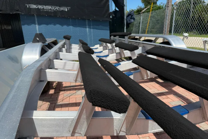 Slide: The Image of 2024 Cobia 350 Center Console boat trailer with padded supports on a brick surface. - 52