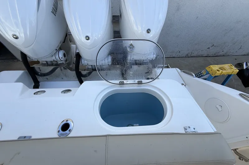 Slide: The Image of 2024 Cobia 350 Center Console boat with open livewell and triple outboard engines. - 16