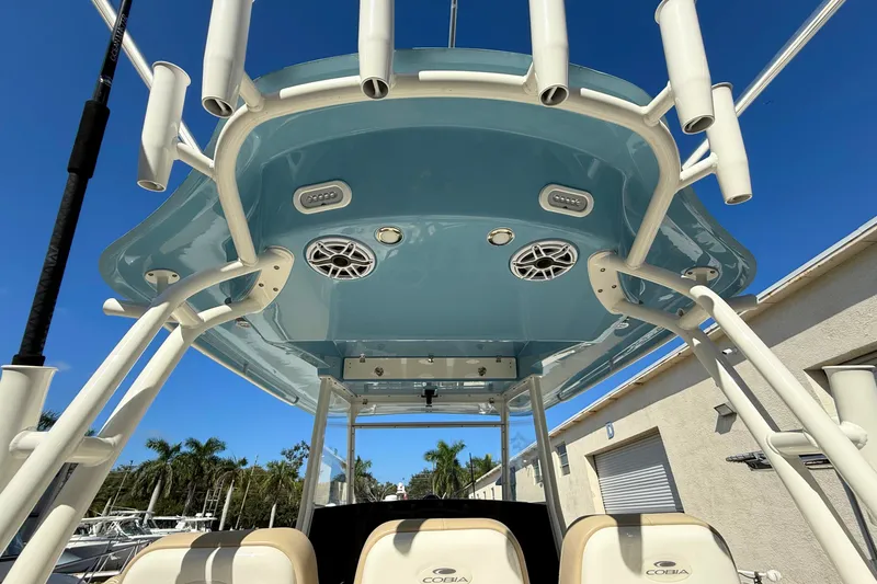 Slide: The Image of 2024 Cobia 350 Center Console boat, featuring overhead speakers and rod holders. - 19