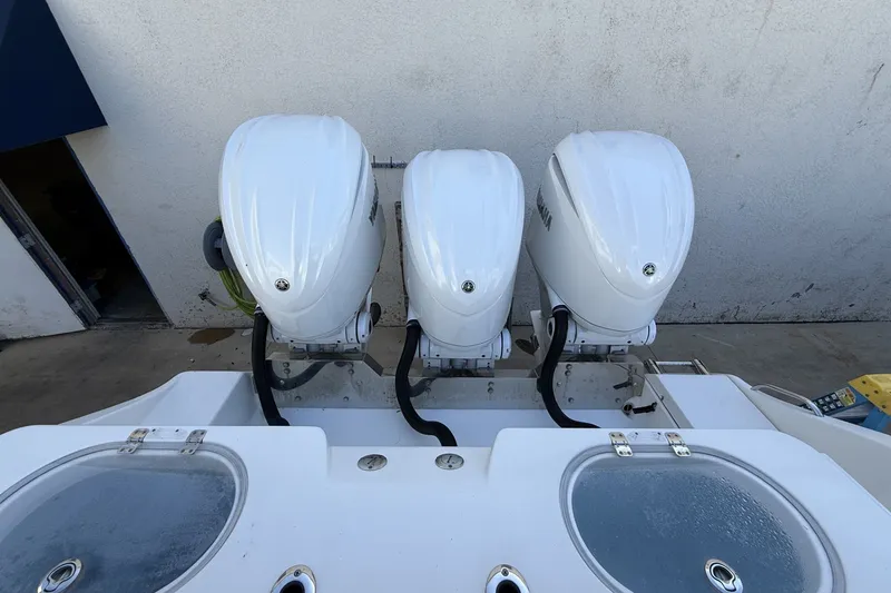 Slide: The Image of Triple outboard engines on a 2024 Cobia 350 Center Console boat. - 14