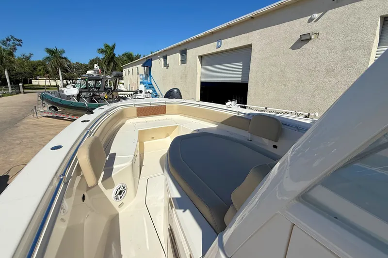 Slide: The Image of 2024 Cobia 350 Center Console boat with spacious seating, docked near a warehouse. - 35