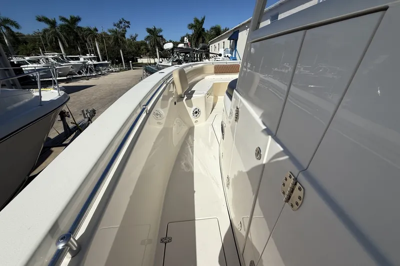 Slide: The Image of 2024 Cobia 350 Center Console boat, sleek design, docked under clear blue sky. - 39