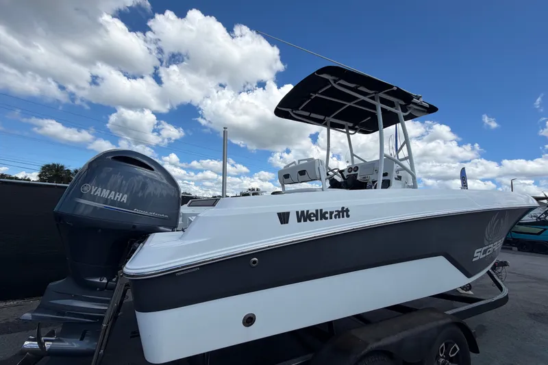 Slide: The Image of 2023 Wellcraft 202 Fisherman boat with Yamaha engine under a blue sky. - 2