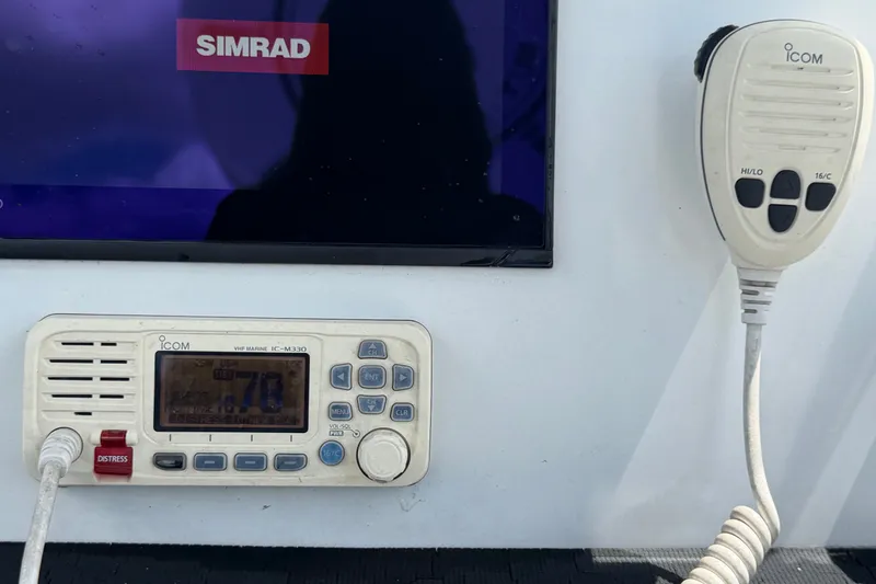 Slide: The Image of VHF marine radio and Simrad display on 2023 Wellcraft 202 Fisherman boat. - 20