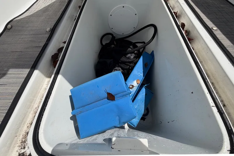 Slide: The Image of An open storage compartment on a boat with blue items and leaves inside. - 27