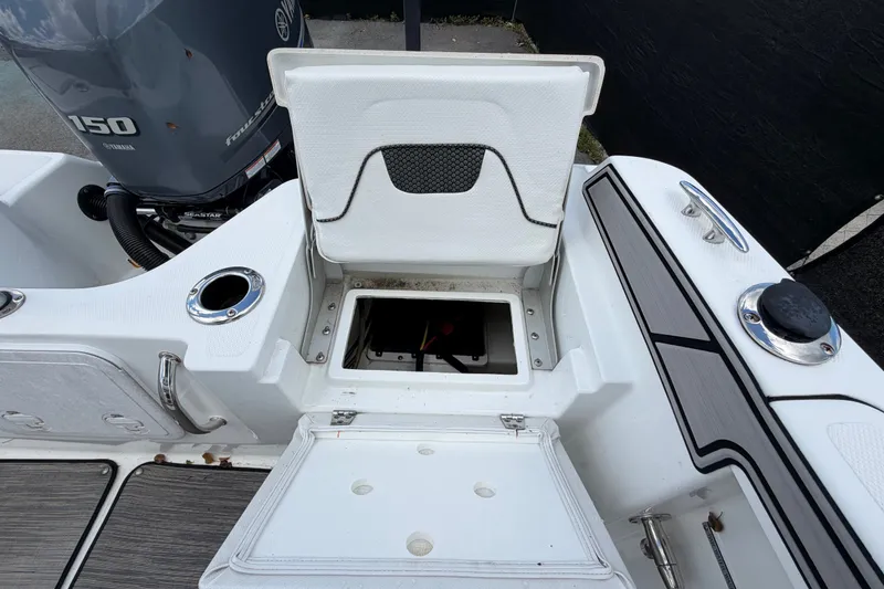 Slide: The Image of 2023 Wellcraft 202 Fisherman boat interior with open storage compartment and Yamaha 150 engine. - 50