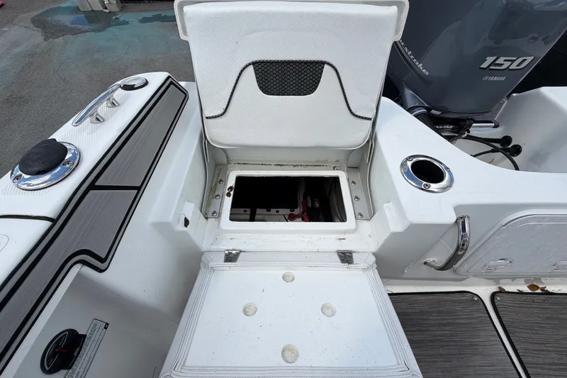 Slide: The Image of The image shows the storage compartment of a 2023 Wellcraft 202 Fisherman with an open lid. - 47