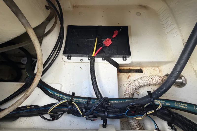 Slide: The Image of 2023 Wellcraft 202 Fisherman boat battery compartment with wiring and hoses. - 51