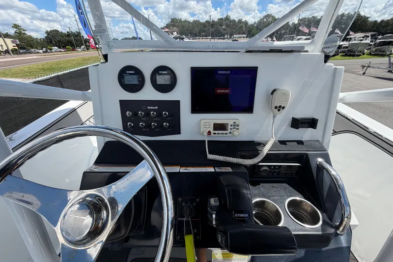 Slide: The Image of 2023 Wellcraft 202 Fisherman boat dashboard with steering wheel and navigation controls. - 16