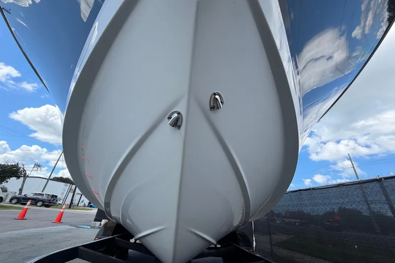 Slide: The Image of 2023 Wellcraft 202 Fisherman boat hull, viewed from below, against a blue sky backdrop. - 9