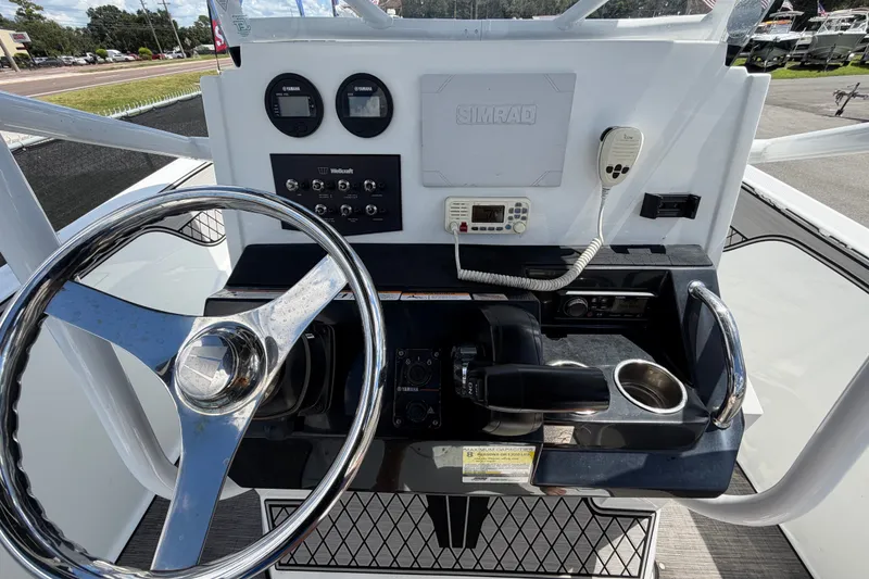 Slide: The Image of 2023 Wellcraft 202 Fisherman boat dashboard with steering wheel and control panel. - 15