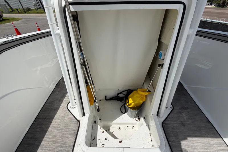 Slide: The Image of 2023 Wellcraft 202 Fisherman boat storage compartment with cleaning supplies and equipment. - 40