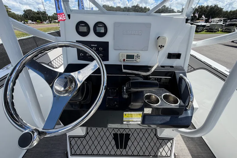 Slide: The Image of 2023 Wellcraft 202 Fisherman boat dashboard with steering wheel and control panel. - 14