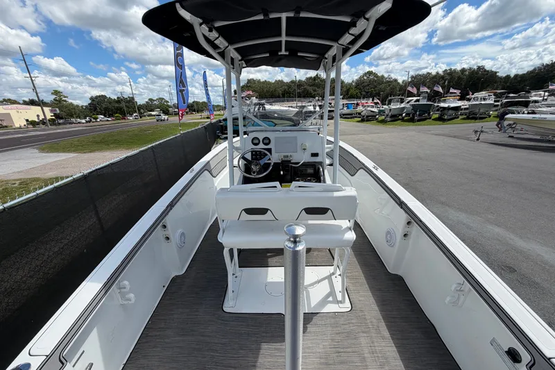 Slide: The Image of 2023 Wellcraft 202 Fisherman boat interior with steering console, docked outdoors. - 10