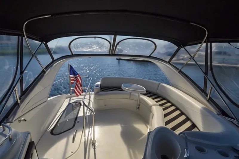 Slide: The Image of 2008 Meridian 391 Sedan yacht interior with seating and American flag, overlooking serene water. - 3