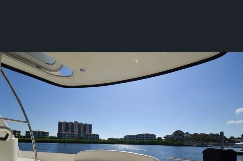 Slide: The Image of View from a 2008 Meridian 391 Sedan yacht, overlooking waterfront buildings under a clear blue sky. - 2
