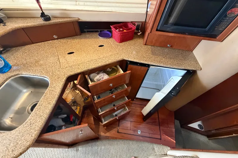 Slide: The Image of 2008 Meridian 391 Sedan yacht kitchen with granite countertops, sink, and open storage cabinets. - 50