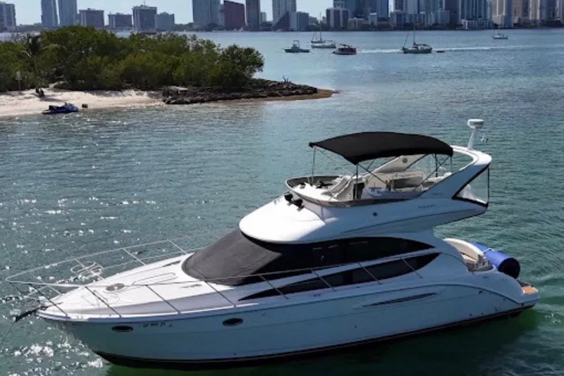 Slide: The Image of A 2008 Meridian 391 Sedan yacht on calm water with a city skyline in the background. - 0