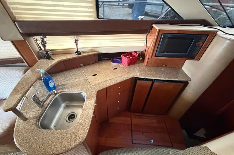 Slide: The Image of 2008 Meridian 391 Sedan yacht kitchen with sink, microwave, and wooden cabinetry. - 42