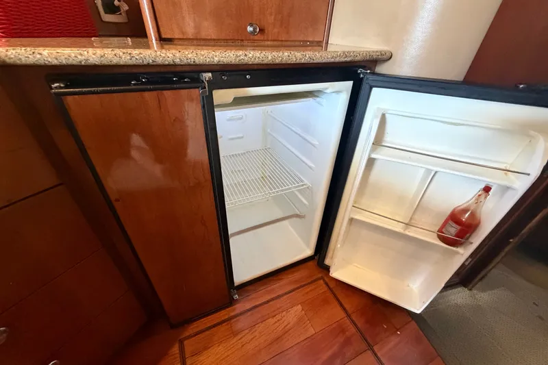 Slide: The Image of Open fridge in 2008 Meridian 391 Sedan yacht kitchen with wooden cabinetry. - 53