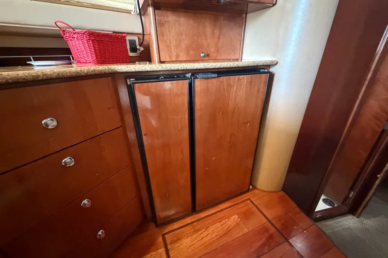 Slide: The Image of Wooden cabinetry and mini fridge inside a 2008 Meridian 391 Sedan yacht interior. - 52